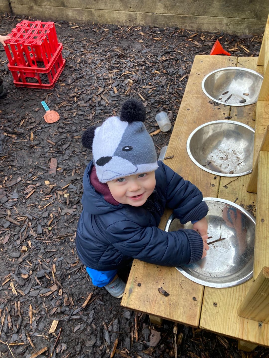 A child outside washing their hands