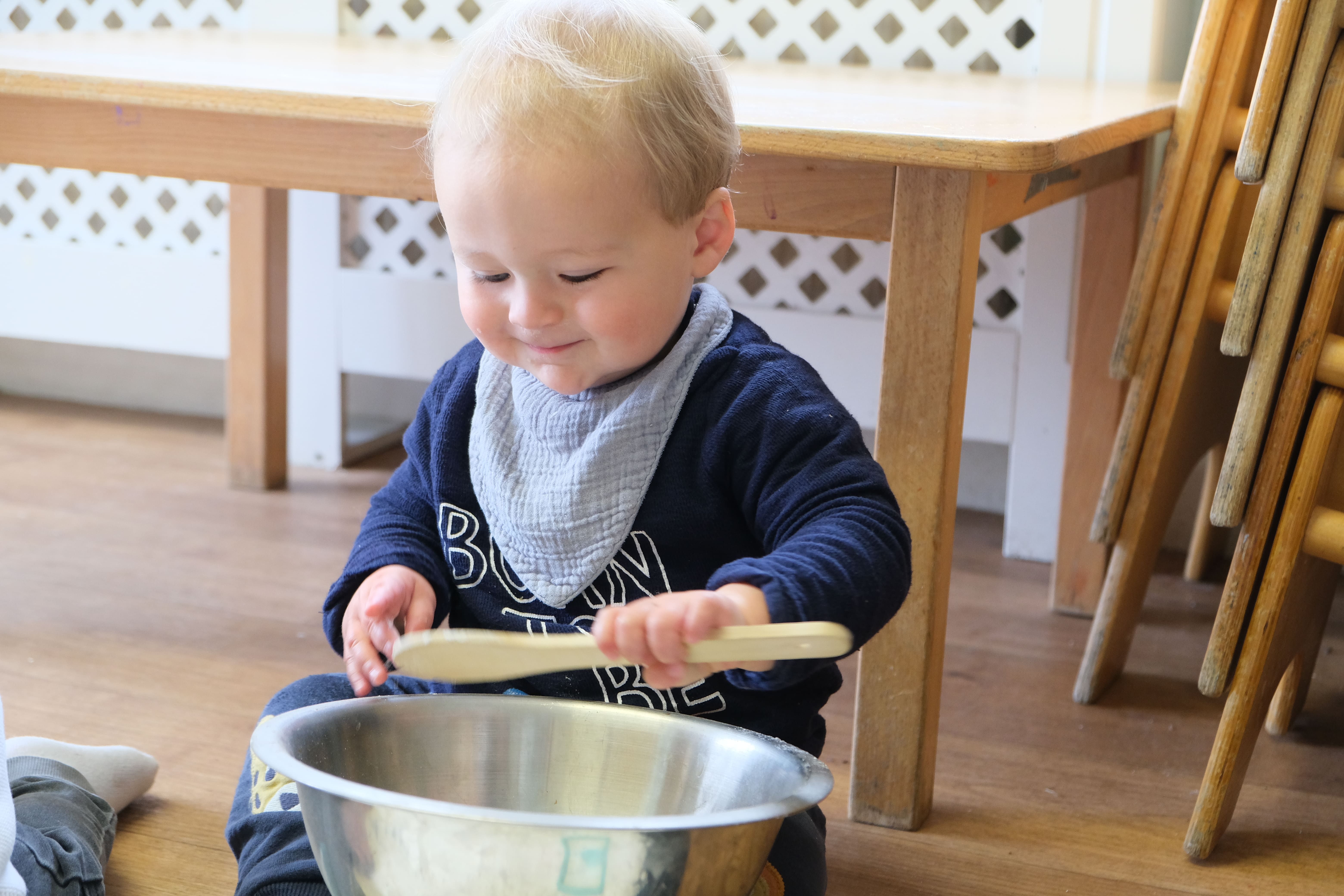 A child at Devon Nurseries playing with a spoon and bowl