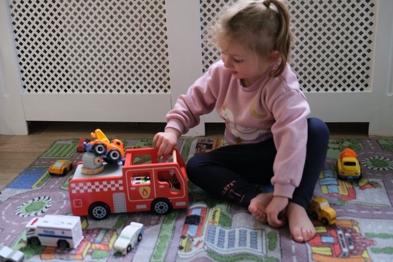 A child at Devon Nurseries playing with a toy fire engine