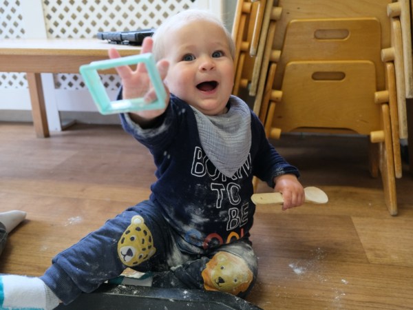 A toddler playing with baking utensils at Devon Nurseries