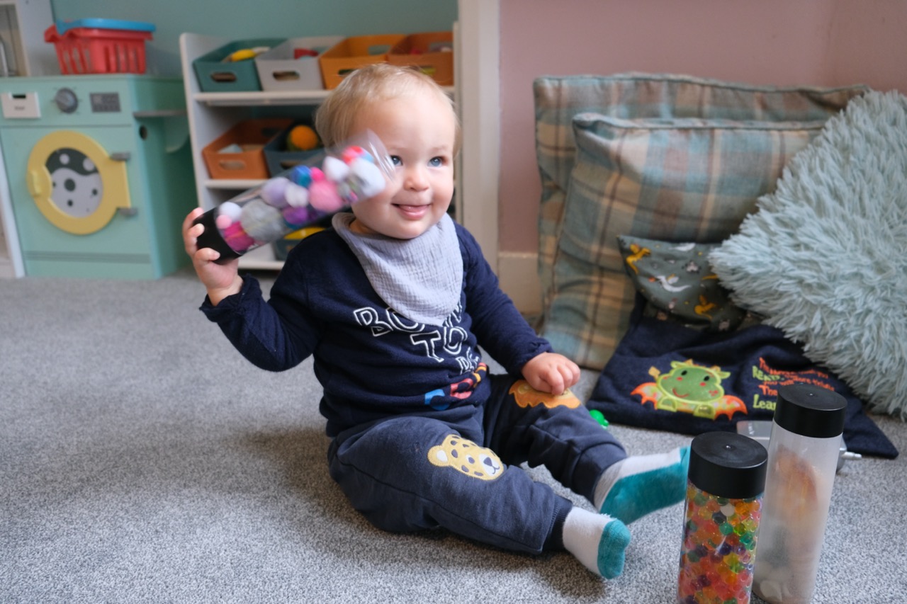 A child playing with shaker instruments at Devon Nurseries